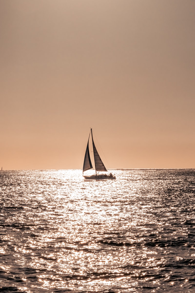 sailboat on sea during sunset